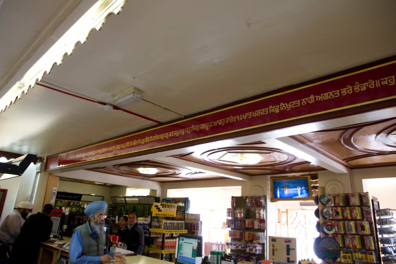 Customers stand at the counter of the Gudwara's in-house hardwear shop