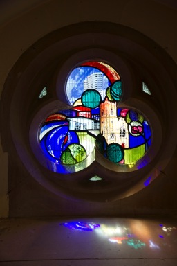 A contemporary stained glass window at St. John's Church, Ladywood. With the high-rises in the background, trees and shrubs in the foreground at the church itself in the middle, it symbolises that St. John's stands at the heart of the inner-city community that it serves.
