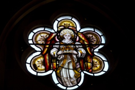 A traditional in style, Victorian era, stained glass window at St. John's Church, Ladywood. The image is of an angel bearing the crown of heaven.