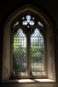 Plain stained glass windows, with light streaming through them, in an alcove of St. John's Church, Ladywood.